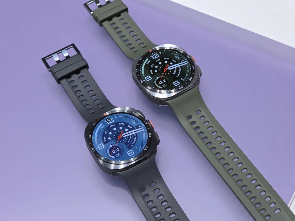 Two round Samsung Galaxy Watch smartwatches with sport bands displaying colorful watch faces